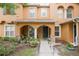 Charming townhome with front porch, archways, and green door in landscaped yard at 6925 Marble Fawn Pl, Riverview, FL 33578
