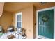 Inviting porch with green door, welcome wreath, and seating area at 6925 Marble Fawn Pl, Riverview, FL 33578