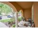 Charming porch with arched columns, seating, and view of the neighborhood at 6925 Marble Fawn Pl, Riverview, FL 33578
