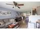Open-concept living room featuring hardwood floors, ceiling fan, and staircase at 6925 Marble Fawn Pl, Riverview, FL 33578