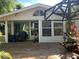 Spacious outdoor deck with green french doors, a window, and a pergola with tropical plants at 715 Riverside Dr, Tarpon Springs, FL 34689