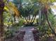 Inviting walkway with brick path and tropical landscaping leading to front entrance at 715 Riverside Dr, Tarpon Springs, FL 34689