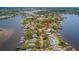 Waterfront home featuring a pool, boat dock, and lush greenery, all on a desirable peninsula at 739 Chesapeake Dr, Tarpon Springs, FL 34689