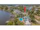 Waterfront property featuring a private pool, dock, and boat lift with lush landscaping at 739 Chesapeake Dr, Tarpon Springs, FL 34689