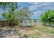 Backyard with mature trees, deck overlooking the water, swing set, and a fenced area at 739 Chesapeake Dr, Tarpon Springs, FL 34689