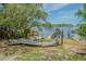 Picturesque backyard area features a dock, swing, and lush green landscaping overlooking the water at 739 Chesapeake Dr, Tarpon Springs, FL 34689