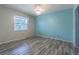 Bedroom with wood-look tile flooring, ceiling fan, and window letting in natural light at 739 Chesapeake Dr, Tarpon Springs, FL 34689