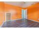Bright bedroom with orange walls, sleek floors, and a convenient closet with an access door at 739 Chesapeake Dr, Tarpon Springs, FL 34689