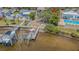 Waterfront home featuring a boat lift, dock, and outdoor lounge space at 739 Chesapeake Dr, Tarpon Springs, FL 34689