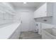 Spacious laundry room with storage cabinets, utility sink, countertop, and access to outside at 739 Chesapeake Dr, Tarpon Springs, FL 34689
