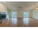 Open living room with hardwood floors, fireplace, built-in shelving, and sliding glass doors to a balcony at 739 Chesapeake Dr, Tarpon Springs, FL 34689