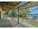 Covered patio with views of the backyard, water access and wooden deck area at 739 Chesapeake Dr, Tarpon Springs, FL 34689