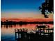 Scenic waterfront view at sunset, featuring a private dock with chairs overlooking the peaceful water at 739 Chesapeake Dr, Tarpon Springs, FL 34689