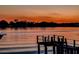Picturesque waterfront view at sunset, featuring a private dock, calming water, and silhouetted treeline at 739 Chesapeake Dr, Tarpon Springs, FL 34689