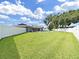 Large backyard with lush green grass, a sparkling pool, and a secure white fence at 800 Embassy Rd, Largo, FL 33771