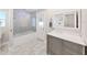 Well-lit bathroom with tiled floors, modern vanity, bathtub, and glass shower, providing a relaxing space at 800 Embassy Rd, Largo, FL 33771