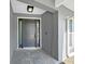 A modern front door, enhanced by sidelights and elegant tile flooring at 800 Embassy Rd, Largo, FL 33771
