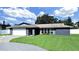 Inviting single-story home with a well-manicured front lawn and a bright garage door at 800 Embassy Rd, Largo, FL 33771