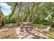 Spacious backyard featuring a fire pit, grill, and hammock under beautiful mature trees, perfect for outdoor relaxation at 8268 Garrison St, Spring Hill, FL 34606
