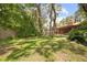A large, grassy backyard is surrounded by mature trees and lush landscaping, offering a serene outdoor space at 8268 Garrison St, Spring Hill, FL 34606