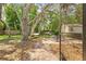Relaxing backyard features mature trees, a hammock, a grill, and seating around a brick paver patio at 8268 Garrison St, Spring Hill, FL 34606