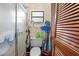 This small bathroom features a toilet and shower with glass doors, next to a louvered-door closet at 8268 Garrison St, Spring Hill, FL 34606