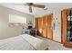 This bedroom features a ceiling fan, closet with wood doors, and a desk with a computer by the window at 8268 Garrison St, Spring Hill, FL 34606