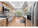 Traditional kitchen with stainless steel appliances and wood cabinets open to a dining area with a window view at 8268 Garrison St, Spring Hill, FL 34606
