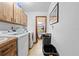 Functional laundry room includes a sink, washer, dryer, upper cabinets, and extra storage space at 8268 Garrison St, Spring Hill, FL 34606