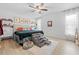Bright main bedroom features a ceiling fan, light wood floors, and ample natural light at 8268 Garrison St, Spring Hill, FL 34606