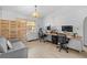 Bright office space with a gray sofa, two desks, and natural light streaming in through a window at 8268 Garrison St, Spring Hill, FL 34606