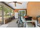This covered patio includes multiple bikes, cooking equipment, and ceiling fan at 8268 Garrison St, Spring Hill, FL 34606