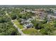 Aerial view of a home featuring a blue shed, manicured lawns, and nearby commercial areas at 8310 Pat Blvd, Tampa, FL 33615