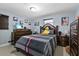 Cozy bedroom with a wooden bed frame, tiled floors, and a charming display of floral artwork on the walls at 8310 Pat Blvd, Tampa, FL 33615