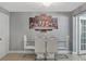 Elegant dining room with a modern glass table, white chairs, and a striking art piece at 8310 Pat Blvd, Tampa, FL 33615