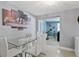 Bright dining space featuring a modern glass table, white chairs, and sliding glass doors to another living space at 8310 Pat Blvd, Tampa, FL 33615