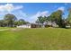 Spacious home featuring a large, lush front lawn with mature trees and an attached garage at 8310 Pat Blvd, Tampa, FL 33615