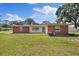 Charming brick home featuring a well-manicured front lawn and classic architectural details at 8310 Pat Blvd, Tampa, FL 33615