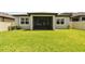 A well-maintained backyard featuring lush green grass and a screened patio at 9316 Crescent Ray Dr, Wesley Chapel, FL 33545