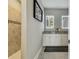 Modern bathroom featuring dual sinks, white cabinets, and tiled shower at 9316 Crescent Ray Dr, Wesley Chapel, FL 33545