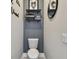 Cozy half-bathroom with charming decor, wooden shelves, and gray accent wall at 9316 Crescent Ray Dr, Wesley Chapel, FL 33545