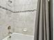 Bathroom featuring tub with tile surround, shower head, and toiletry rack at 9316 Crescent Ray Dr, Wesley Chapel, FL 33545
