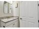 Bathroom featuring white cabinet, granite countertop, and a sleek mirror at 9316 Crescent Ray Dr, Wesley Chapel, FL 33545