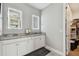 Modern bathroom features double sinks with granite countertop and illuminated mirrors at 9316 Crescent Ray Dr, Wesley Chapel, FL 33545