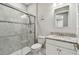 Well-lit bathroom featuring a glass shower door and modern granite vanity at 9316 Crescent Ray Dr, Wesley Chapel, FL 33545