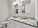 Modern bathroom featuring a double sink vanity with granite countertops and stylish mirrors at 9316 Crescent Ray Dr, Wesley Chapel, FL 33545