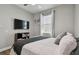 Comfortable bedroom with a flat-screen TV, neutral walls, and natural light at 9316 Crescent Ray Dr, Wesley Chapel, FL 33545