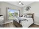Bright bedroom with a large window, ceiling fan, and modern decor at 9316 Crescent Ray Dr, Wesley Chapel, FL 33545