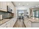 Well-equipped kitchen features granite counters, white cabinetry, and a breakfast bar for casual dining at 9316 Crescent Ray Dr, Wesley Chapel, FL 33545