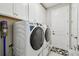 Laundry room with white cabinets, washer, dryer, and tile flooring at 9316 Crescent Ray Dr, Wesley Chapel, FL 33545